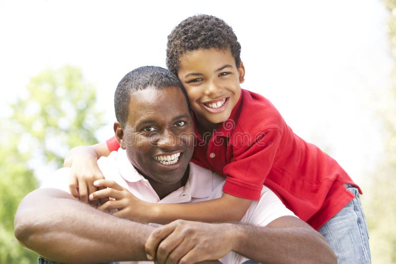 Portrait Of Father And Son In Park Smiling. Portrait Of Father And Son In Park Smiling