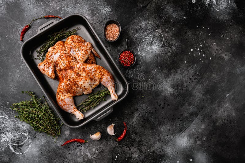сырая курица с маринованным цельным цветом для bbq на черном темно-каменном столе, вид сверху плоский с копировальным пространство стоковое изображение