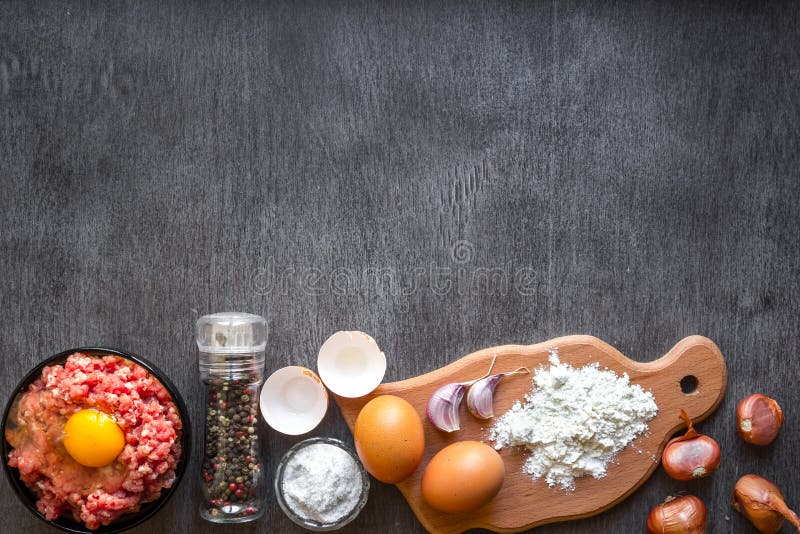Сырцовое семенить мясо с яичным желтком, деревянной разделочной доской на деревянной предпосылке стоковые изображения