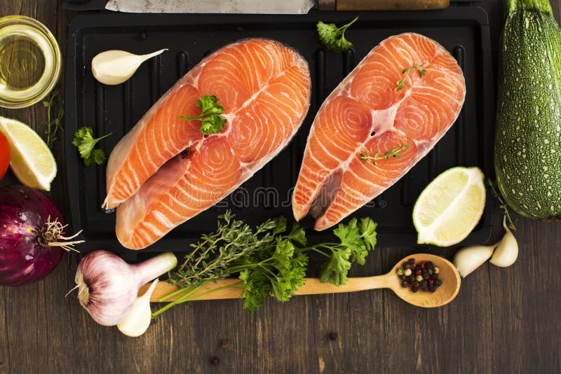 Сырцовые salmon стейки над деревянной предпосылкой стоковые изображения rf Сырцовые salmon стейки над деревянной предпосылкой стоковые изображения rf