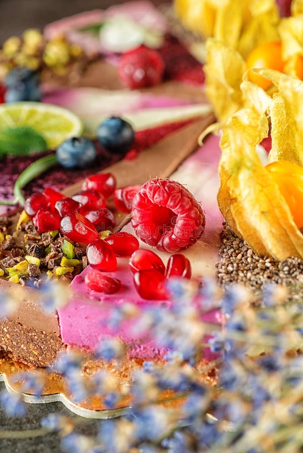 Сырцовые торты vegan при плодоовощ и семена, украшенные с цветком, фотография продукта для patisserie стоковые фотографии rf Сырцовые торты vegan при плодоовощ и семена, украшенные с цветком, фотография продукта для patisserie стоковые фотографии rf