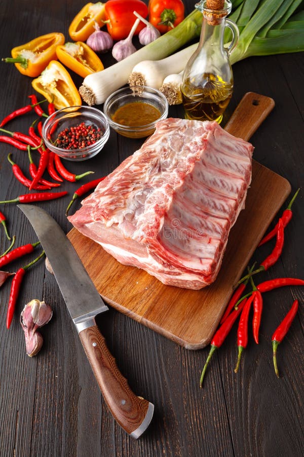 Сырцовый стейк нервюры телятины свежего мяса на косточке и приправы на темном bac стоковые изображения rf Сырцовый стейк нервюры телятины свежего мяса на косточке и приправы на темном bac стоковые изображения rf
