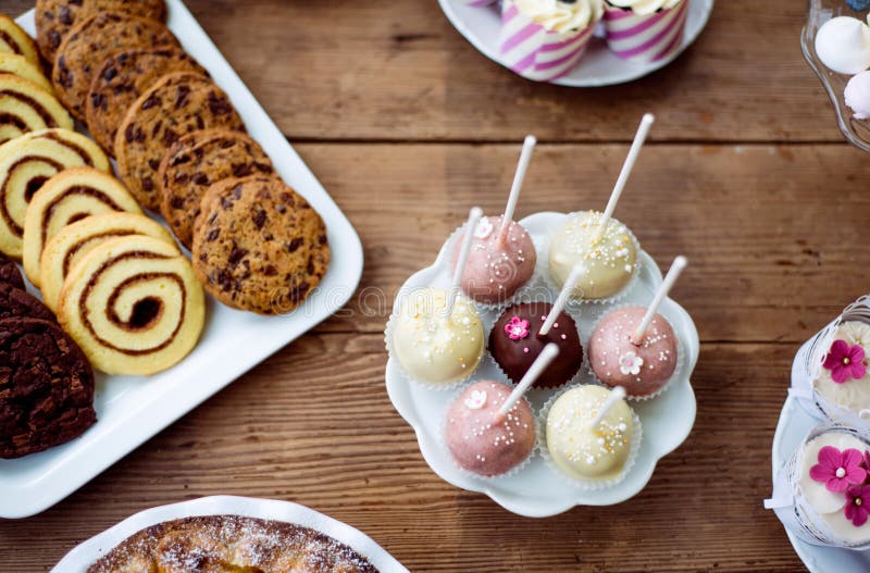 Таблица с cakepops, печеньями и пирожными Деревянная предпосылка стоковые изображения Таблица с cakepops, печеньями и пирожными Деревянная предпосылка стоковые изображения