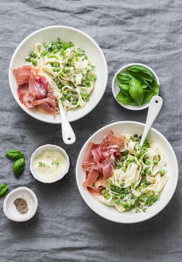 Таблица обеда в среднеземноморском стиле Макаронные изделия Fettuccine с сметанообразным соусом, зелеными горохами и ветчиной на стоковая фотография Таблица обеда в среднеземноморском стиле Макаронные изделия Fettuccine с сметанообразным соусом, зелеными горохами и ветчиной на стоковая фотография