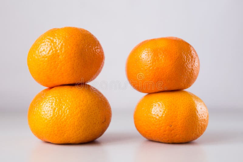 4 ripe tangerines on a light gray background. 4 ripe tangerines on a light gray background