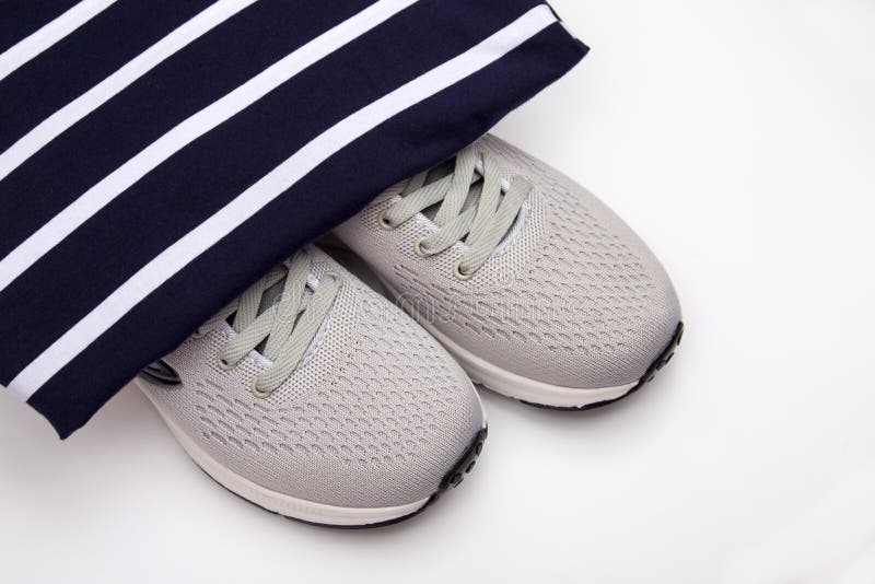 Тапки на striped предпосылке Ботинки моды детей на черно-белой striped предпосылке Ботинки спорт женщин r стоковые изображения Тапки на striped предпосылке Ботинки моды детей на черно-белой striped предпосылке Ботинки спорт женщин r стоковые изображения