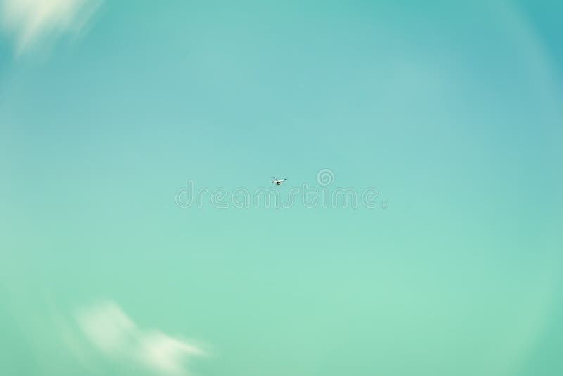 Texture of sky, beautiful turquoise or azure color, white fluffy clouds. High in the sky flies copter, drone, quadrocopter. For modern background, wallpaper or banner design. Lots of place for writing text around it. Texture of sky, beautiful turquoise or azure color, white fluffy clouds. High in the sky flies copter, drone, quadrocopter. For modern background, wallpaper or banner design. Lots of place for writing text around it