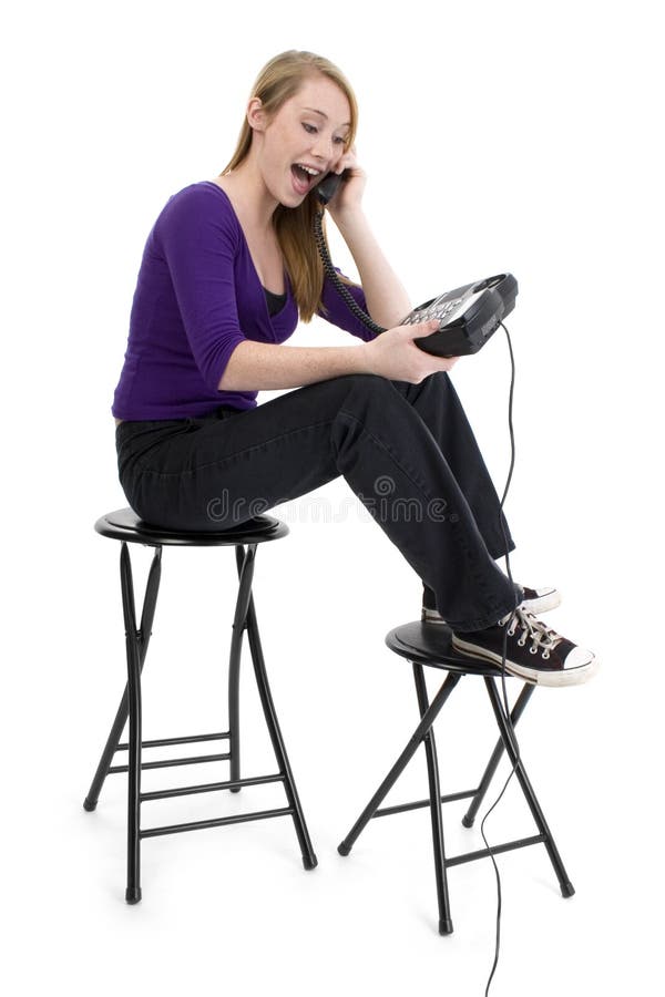 Beautiful fourteen year old girl laughing on telephone. Shot in studio over white. Beautiful fourteen year old girl laughing on telephone. Shot in studio over white.