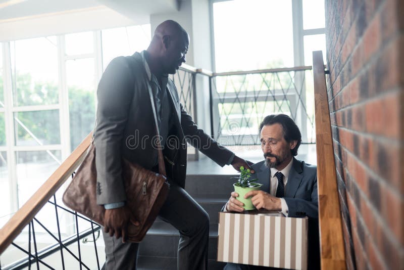 Темнокожий друг говоря с коллегой после получать резервный стоковые фото