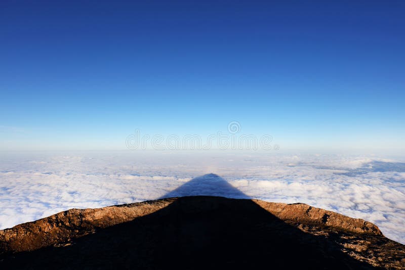 Тень вулкана Pico запроектировала на море облаков на восходе солнца стоковое изображение Тень вулкана Pico запроектировала на море облаков на восходе солнца стоковое изображение