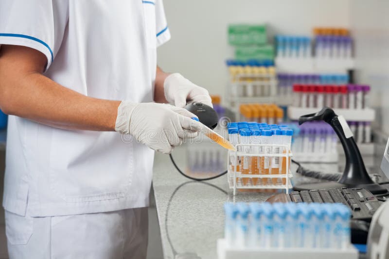 Midsection of male technician scanning barcode on medical sample in laboratory. Midsection of male technician scanning barcode on medical sample in laboratory