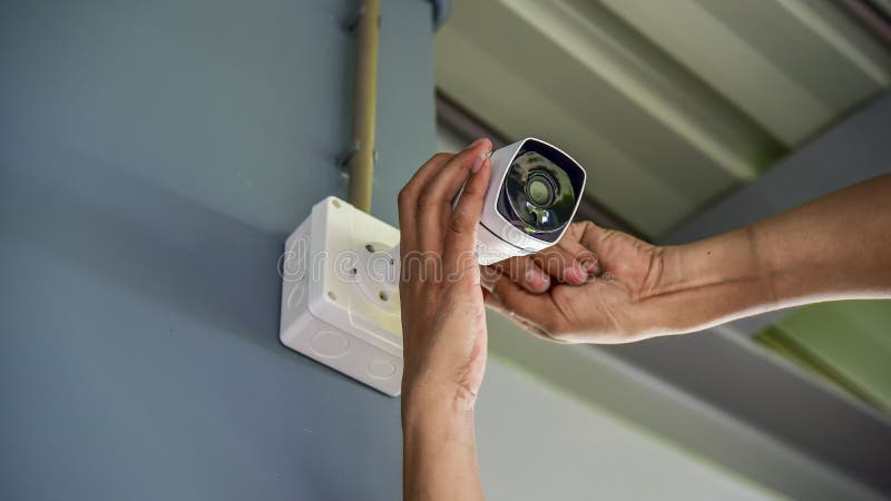 Техник устанавливая беспроводную камеру CCTV привинченный для домашней системы безопасности и установленного w стоковые фотографии rf Техник устанавливая беспроводную камеру CCTV привинченный для домашней системы безопасности и установленного w стоковые фотографии rf