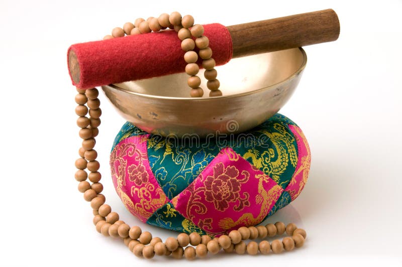 Tibetan singing bowl on quilted pad with sandalwood prayer beads. Tibetan singing bowl on quilted pad with sandalwood prayer beads