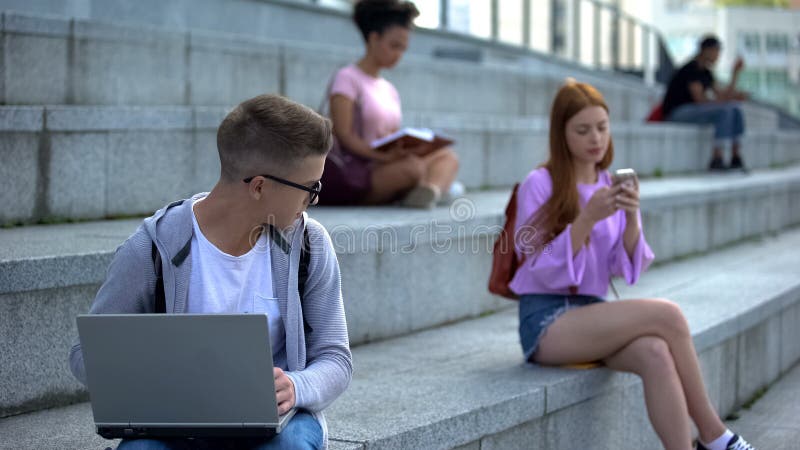 Timid male pupil laptop feeling shy looking pretty female classmate insecurities, stock photo. Timid male pupil laptop feeling shy looking pretty female classmate insecurities, stock photo