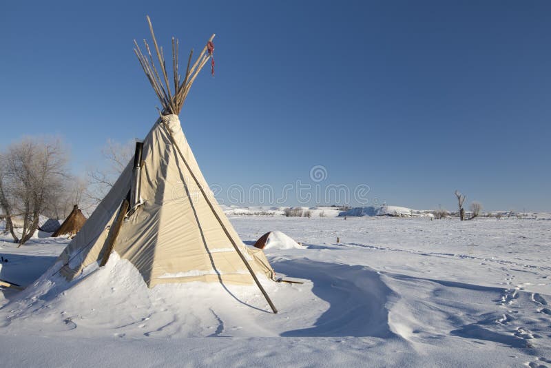Типи на крае лагеря Oceti Sakowin с холмом черепахи в предпосылке, пушечном ядре, Северной Дакоте, США, январе 2017 стоковое фото Типи на крае лагеря Oceti Sakowin с холмом черепахи в предпосылке, пушечном ядре, Северной Дакоте, США, январе 2017 стоковое фото