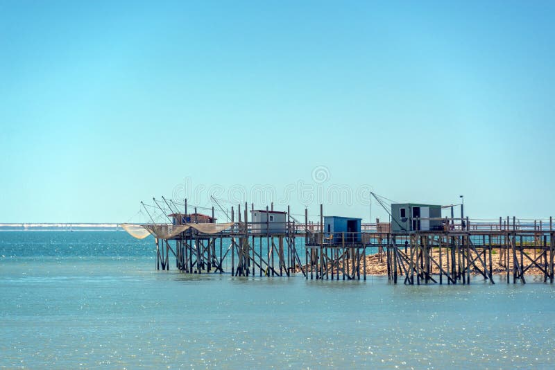 Типичные старые деревянные избы рыбачить на ходулях в Атлантическом океане недалеко от города ла-рошель Франции