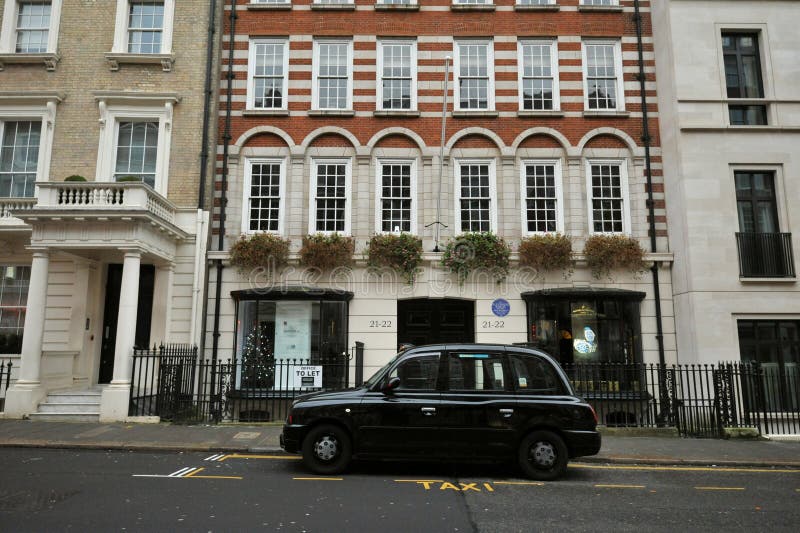 Типичный дом в Mayfair Лондоне с типичной черной такси стоковые изображения