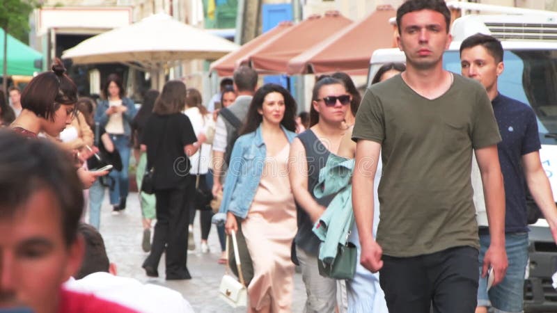 толпа людей, гуляющих по городу туристами, сидящих в летнем открытом кафе пешеходной зоны европейской городской жизни b