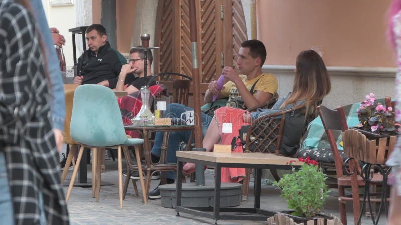 толпа людей, гуляющих по городу туристами, сидящих в летнем открытом кафе пешеходной зоны европейской городской жизни b