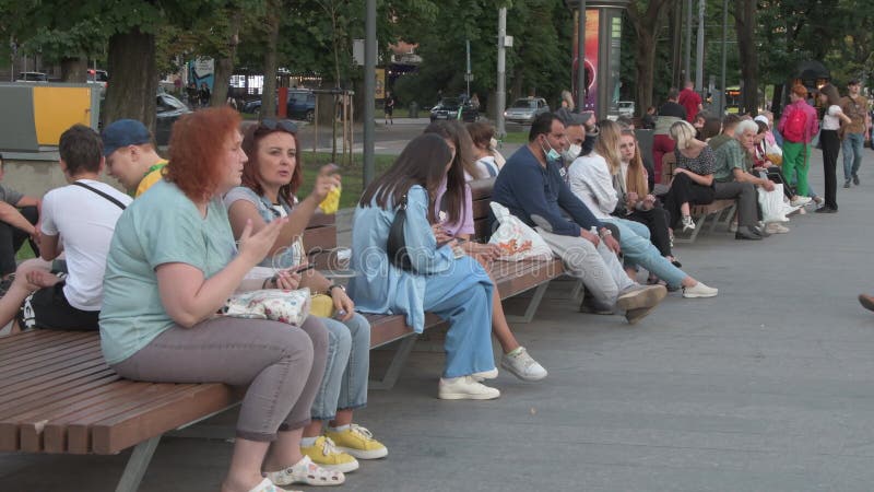 толпа людей, гуляющих по городу туристами, сидящих в летнем открытом кафе пешеходной зоны европейской городской жизни b