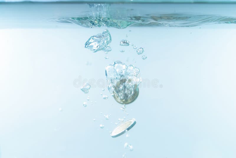 Photo of Coins sinking in the water . Photo of Coins sinking in the water .