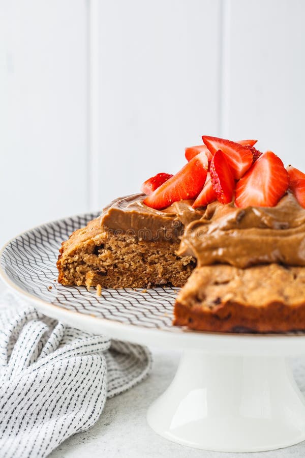 Торт Vegan с темными шоколадом, клубниками и сливк шоколада на белом блюде стоковая фотография rf Торт Vegan с темными шоколадом, клубниками и сливк шоколада на белом блюде стоковая фотография rf
