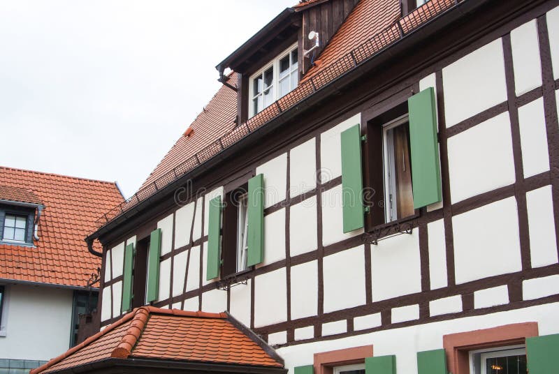 Традиционная немецкая деревня полу-timbered дом с деревянными штарками украшения и зеленого цвета окон стоковая фотография rf Традиционная немецкая деревня полу-timbered дом с деревянными штарками украшения и зеленого цвета окон стоковая фотография rf