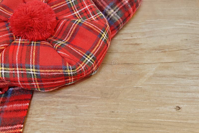 Традиционные шотландские красные Bonnet и шарф тартана на деревянной доске стоковые фото Традиционные шотландские красные Bonnet и шарф тартана на деревянной доске стоковые фото