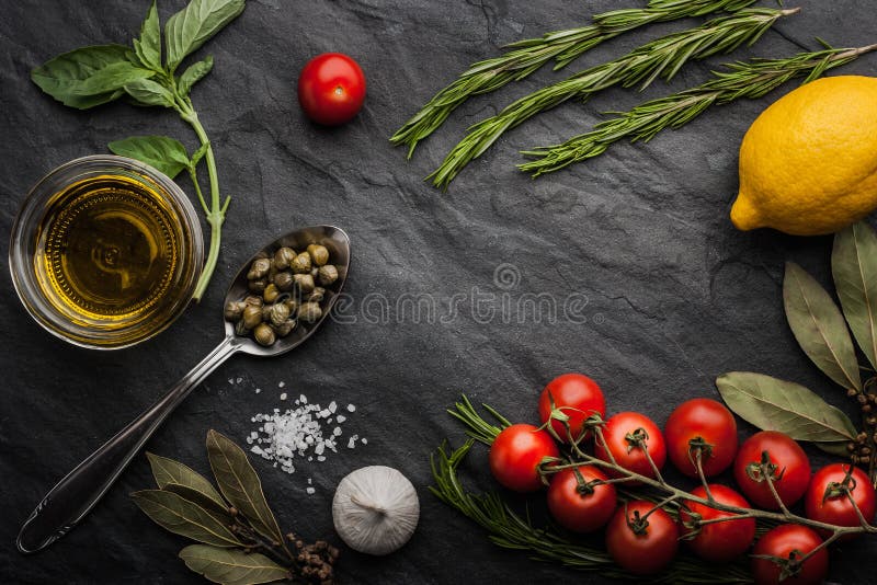Травы смешивают с томатами, лимоном и оливковым маслом на черной каменной таблице стоковое изображение Травы смешивают с томатами, лимоном и оливковым маслом на черной каменной таблице стоковое изображение