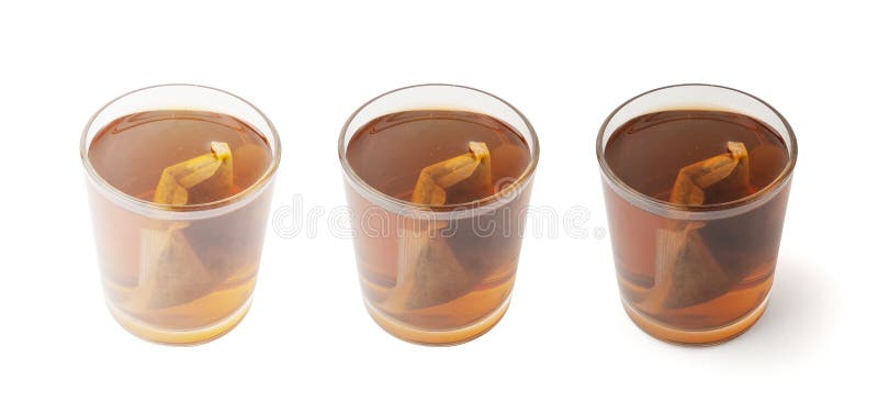 Травяной чай саше в стеклянной горячей воде с ромашкой и гиперикумом или St. стоковое фото