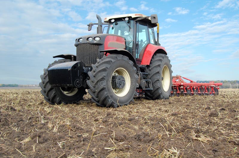 Tractor and disc harrow makes soil tillage. Tractor and disc harrow makes soil tillage