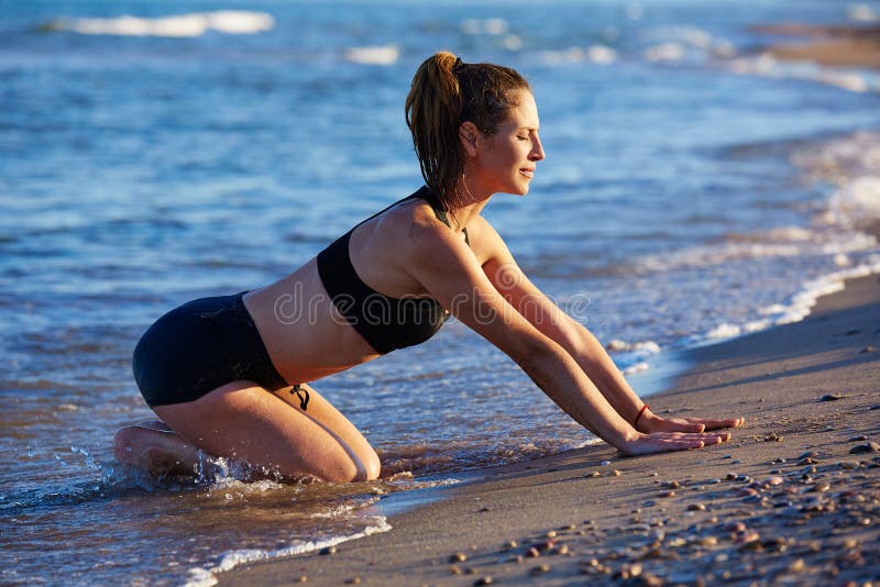 Тренировка разминки йоги Pilates внешняя на пляже стоковые фото Тренировка разминки йоги Pilates внешняя на пляже стоковые фото