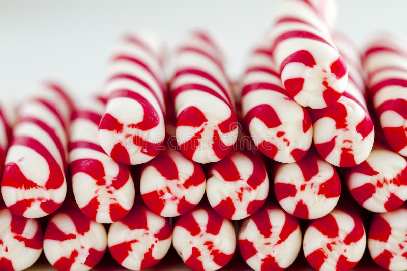 Close up of rows of ends of red and white striped candy canes and peppermint sticks. Close up of rows of ends of red and white striped candy canes and peppermint sticks