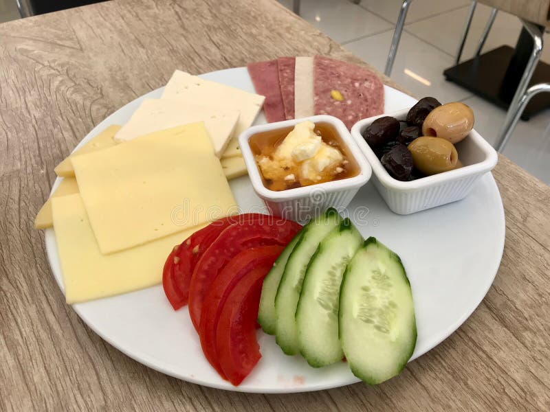 Турецкая плита завтрака с медом, маслом Cream Kaymak, сыром, кусками огурца, оливками, ветчиной и томатами стоковая фотография rf Турецкая плита завтрака с медом, маслом Cream Kaymak, сыром, кусками огурца, оливками, ветчиной и томатами стоковая фотография rf