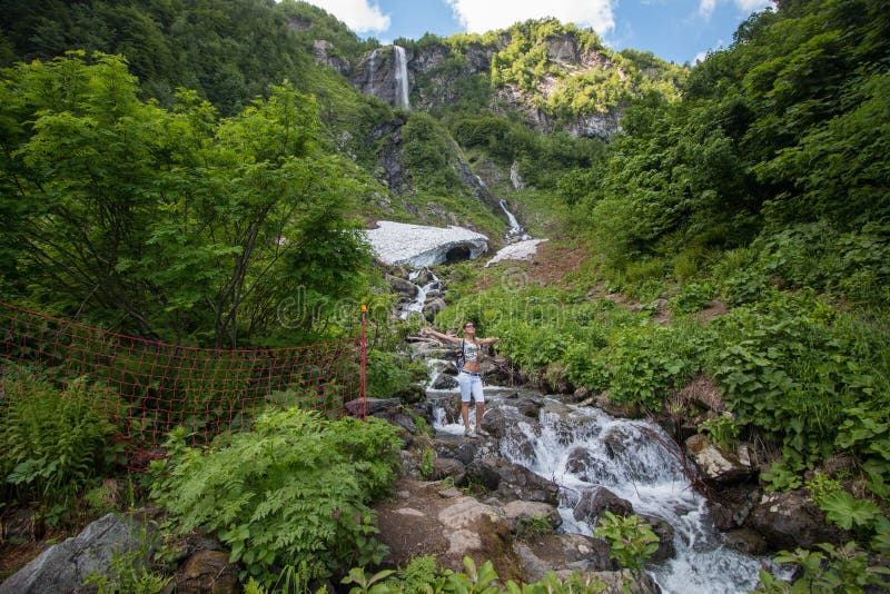 Туристическая девушка пришла к водопаду стоковое фото