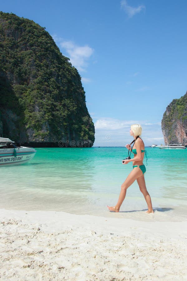 Туристская женщина нося зеленое бикини идя на красивый пляж, остров Phi Phi (Phi Ley) Phi Ko, провинцию Krabi Таиланда стоковая фотография Туристская женщина нося зеленое бикини идя на красивый пляж, остров Phi Phi (Phi Ley) Phi Ko, провинцию Krabi Таиланда стоковая фотография