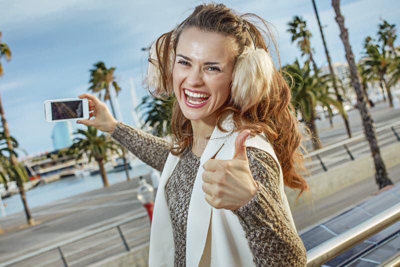 Туристская женщина показывая большие пальцы руки вверх и принимая фото с smartphone стоковые фото Туристская женщина показывая большие пальцы руки вверх и принимая фото с smartphone стоковые фото