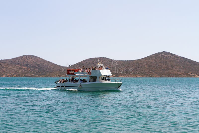 Туристская шлюпка посещая остров Spinalonga, Крит стоковое фото Туристская шлюпка посещая остров Spinalonga, Крит стоковое фото