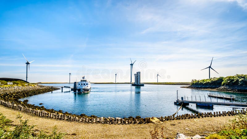 Туристская шлюпка на барьере штормового нагона работ перепада на Oosterschelde уходя от острова Neeltje Jans стоковые изображения Туристская шлюпка на барьере штормового нагона работ перепада на Oosterschelde уходя от острова Neeltje Jans стоковые изображения