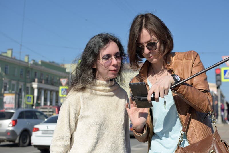 Туристы молодых дам делают selfies на мосте в Санкт-Петербурге, России, и имеют потеху перед камерой стоковая фотография rf Туристы молодых дам делают selfies на мосте в Санкт-Петербурге, России, и имеют потеху перед камерой стоковая фотография rf