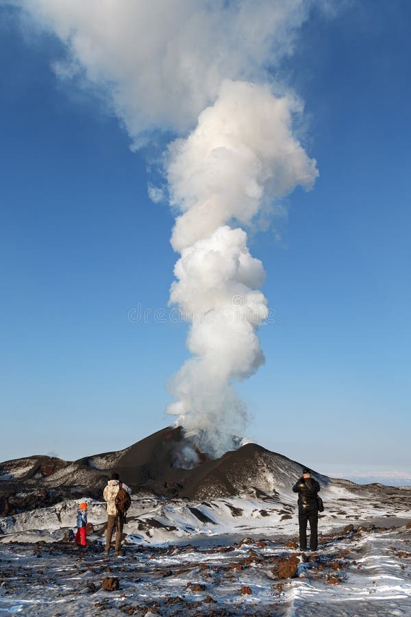 Туристы наблюдая извержение вулкана Tolbachik, выкидывая лаву, пар, газ и золу kamchatka стоковые изображения Туристы наблюдая извержение вулкана Tolbachik, выкидывая лаву, пар, газ и золу kamchatka стоковые изображения