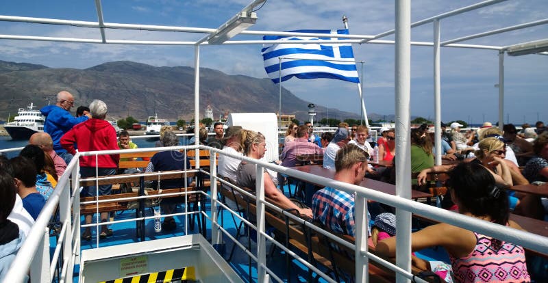Туристы плавая на открытой палубе на корабле для путешествия к заливу Balos стоковая фотография rf Туристы плавая на открытой палубе на корабле для путешествия к заливу Balos стоковая фотография rf