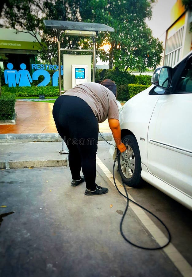 Тучные женщины заполняют автошину в насосе стоковое изображение Тучные женщины заполняют автошину в насосе стоковое изображение