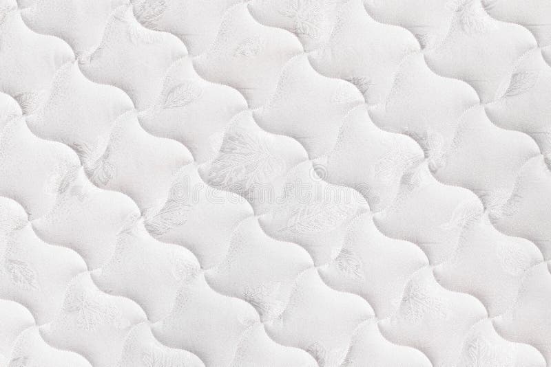 Background of soft comfortable quilted white mattress. Background of soft comfortable quilted white mattress