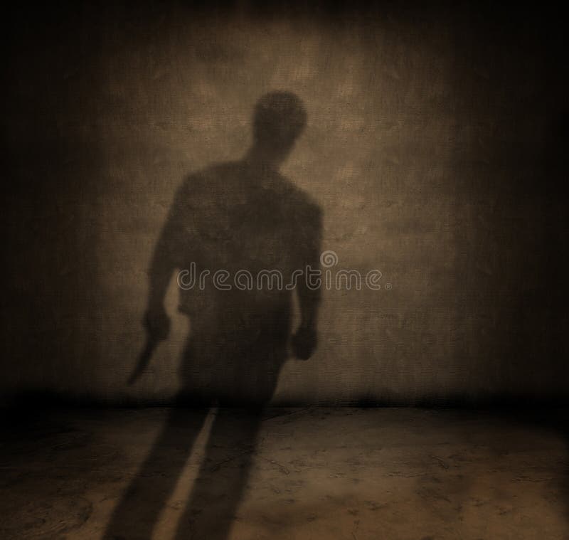 Shadow of a man with a knife in a dark grungy room. Shadow of a man with a knife in a dark grungy room