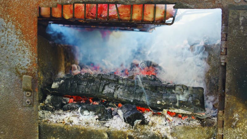 угли в огне. мясные стейки на гриль-стойке, приготовленные на открытом огне