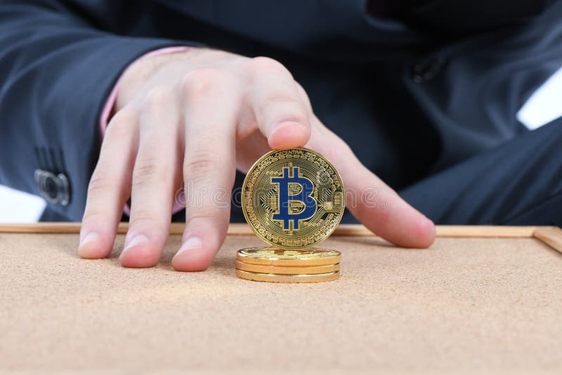 Удерживание золотое Bitcoin руки человека на коричневой текстурированной предпосылке пробочки стоковые фото Удерживание золотое Bitcoin руки человека на коричневой текстурированной предпосылке пробочки стоковые фото