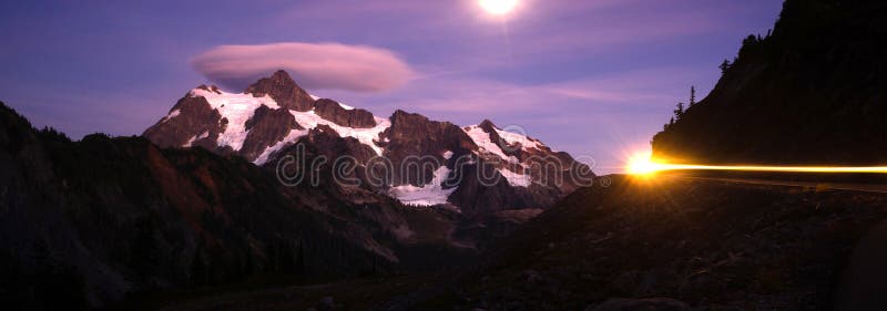 Уединённый автомобиль проходит дальше полнолуние Mt Shuksan проезжей части стоковые изображения rf Уединённый автомобиль проходит дальше полнолуние Mt Shuksan проезжей части стоковые изображения rf