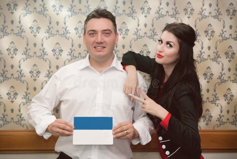 Укомплектуйте личным составом держать плакат и склонность девушки на его плече стоковое изображение