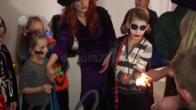 Украина, Виннице 31-ое октября 2019: Праздник хэллоуин Много детей, весело Ведьма горит руку мальчика